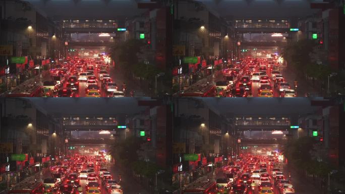 雨夜，从空中俯瞰城市道路上交通堵塞的许多汽车。红色的背光反射在潮湿的沥青上