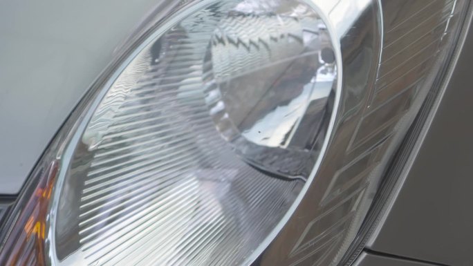 汽车前灯由透明塑料制成，带有反射镜。