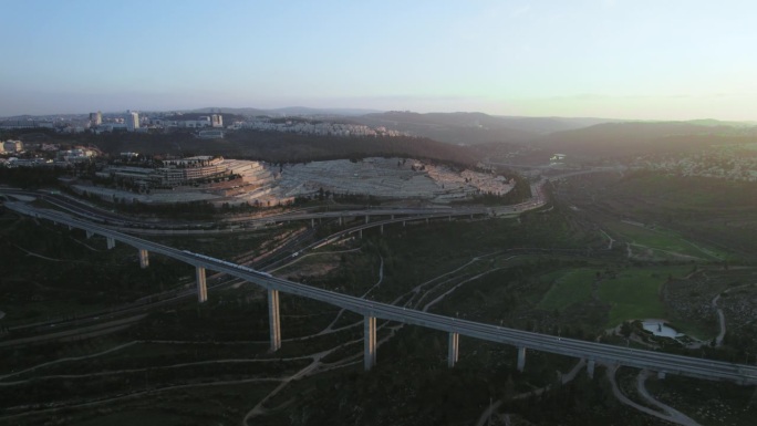 在以色列耶路撒冷入口处，一列客运列车正通过哈哈梅努霍特公墓前的一座大桥。这列现代化的火车在基德隆山谷