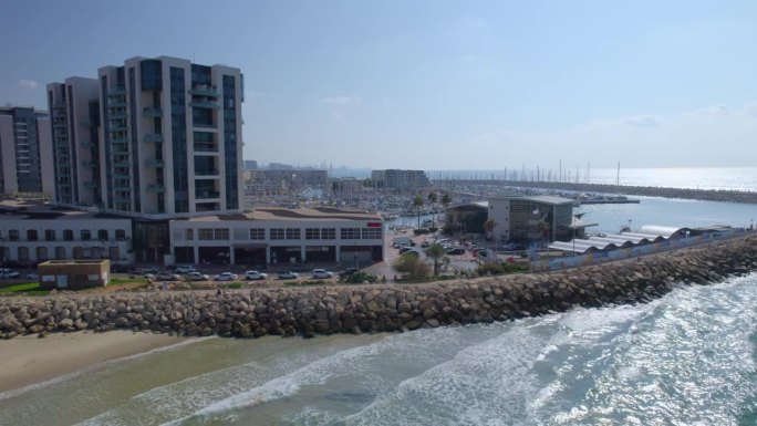 停泊在以色列赫兹利亚码头的游艇。酒店和豪华住宅周围-无人机视差拍摄-地中海