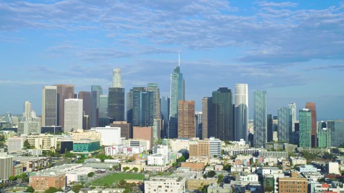 无人机从左至右建立全景洛杉矶加利福尼亚摩天大楼，戏剧性的灰色多云天空