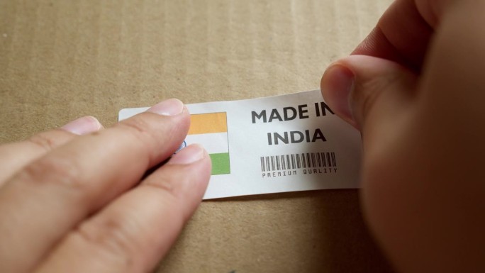 手应用在印度制造的旗帜标签上的运输箱与产品优质条码。制造和交付。产品出厂进出口。