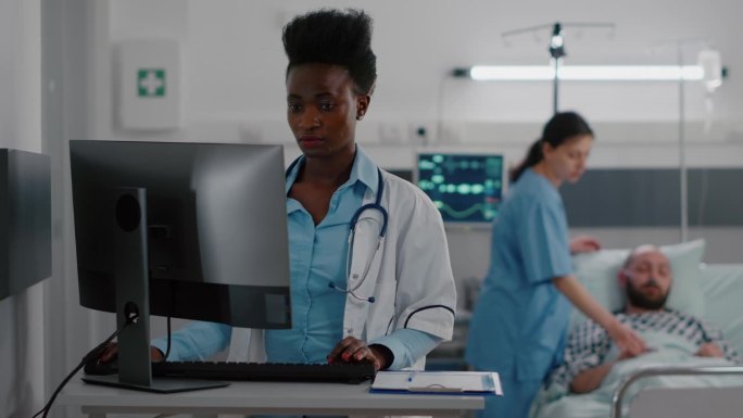 非裔美国医生在电脑上输入医学专业知识的正面视图