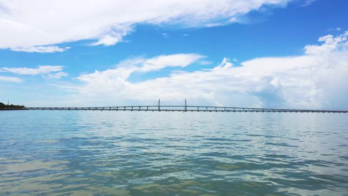 蓝天白云跨海大桥贴近海面高清航拍素材