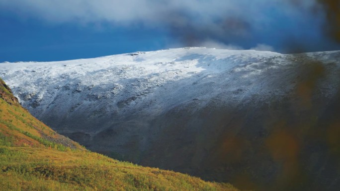 秋天，挪威苔原上的高山和丘陵上新下的雪。视差视频。