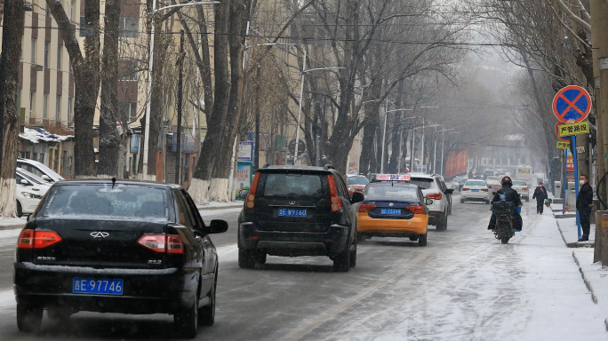 下雪天行驶的汽车和城市忙碌的生活 扫雪