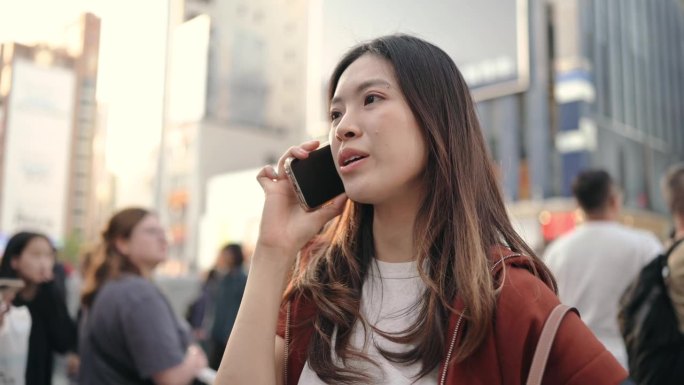 一名亚洲游客在日本道顿堀与她的家人通电话