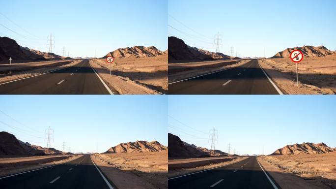 慢动作汽车行驶在空旷的沙漠沥青公路上，没有手机禁止通行的路牌。路边的沙山和蓝天里的烈日
