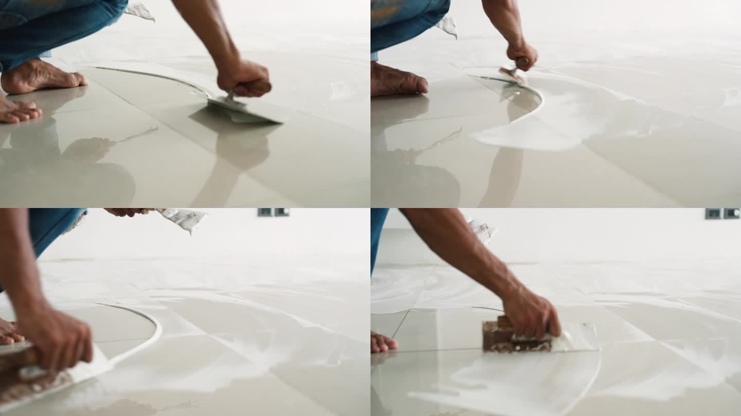 工人用抹灰抹刀在地板上抹灰平整，然后再把强化板铺在地板上
