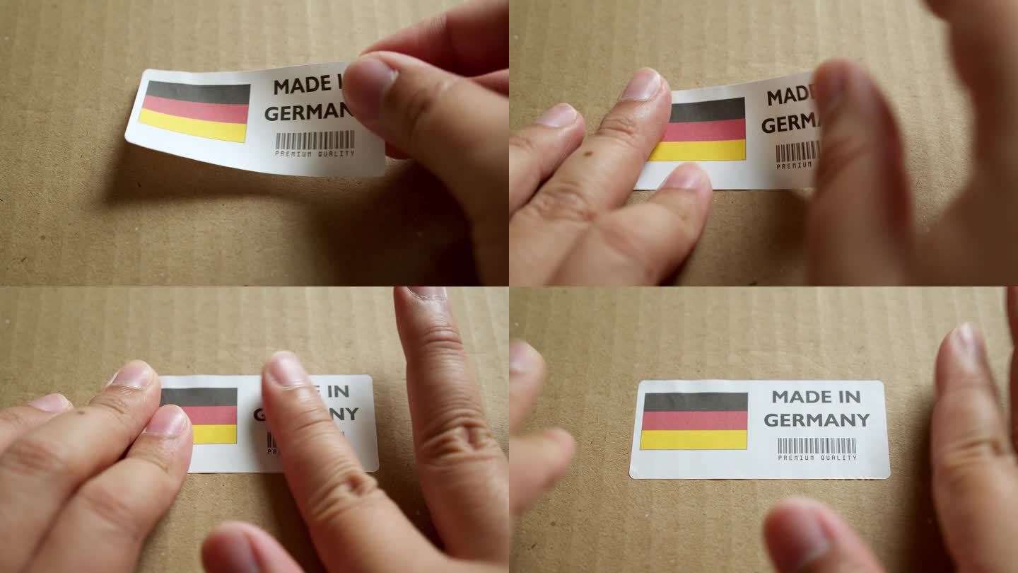 用手将德国制造的旗帜标签贴在带有产品优质条形码的运输箱上。制造和交付。产品出厂进出口。