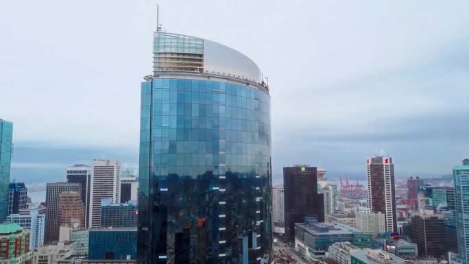 高角度无人机平移拍摄温哥华市。近景:闪亮的新玻璃摩天大楼
