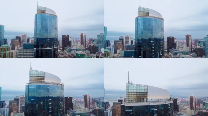 高角度无人机平移拍摄温哥华市。近景:闪亮的新玻璃摩天大楼