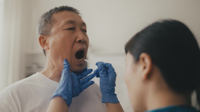 女耳鼻喉科医生检查老人的喉咙，进行健康检查