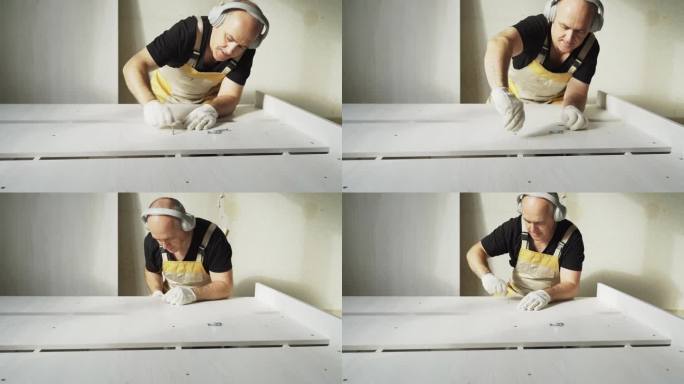 一名工人正在用钉钉固定床的部件。