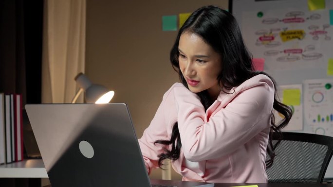 办公室综合症概念。年轻漂亮的亚洲女商人患有办公室综合症，在长时间使用笔记本电脑工作后，身体的一部分出