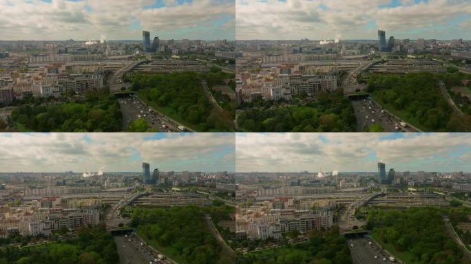 夏天巴黎街头的建立镜头。无人机拍摄的法国街道上挤满了汽车和人。鸟瞰图，在树木和交通之上，被法国建筑和
