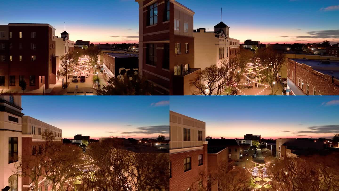在弗吉尼亚州汉普顿的小巷上，戏剧性的天空。夕阳覆盖了市中心的皇后大道。航拍镜头，镜头向前移动