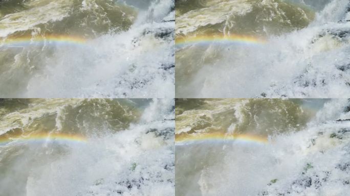 五彩缤纷的水从悬崖边缘飞入彩虹覆盖的大跳水池，慢动作落入阳光明媚的伊瓜苏瀑布，阿根廷，南美洲的侵略性