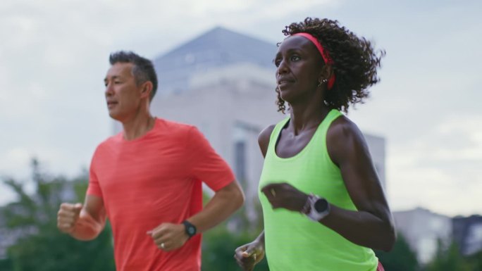 SLO MO TS健美亚洲男人和健美黑人女人在城市跑步