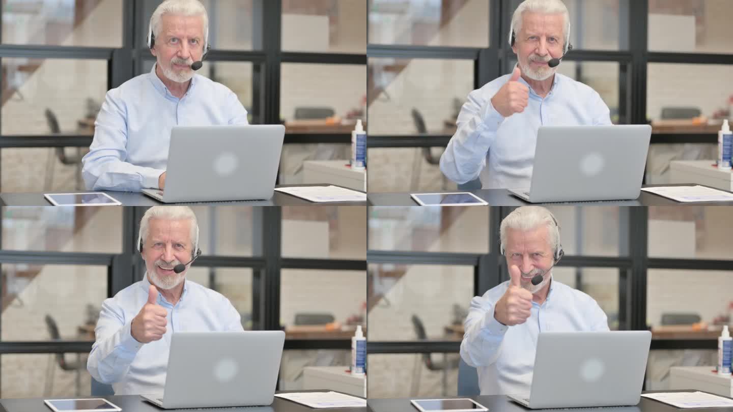 在呼叫中心，一位戴着耳机使用笔记本电脑的老人竖起了大拇指