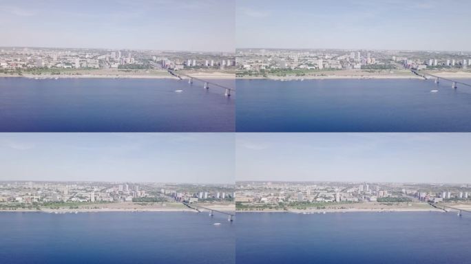 沿着伏尔加河缓缓飞行的鸟瞰图，伏尔加格勒-克拉斯诺洛博斯克大桥上有塔和建筑。俄罗斯伏尔加格勒的伏尔加