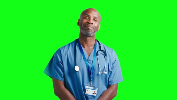 工作室肖像微笑成熟的医生或护士穿着工作服对绿屏幕