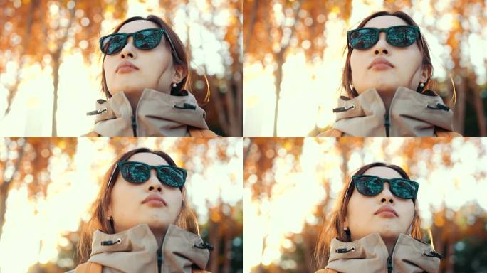 戴着反光太阳镜的女人正在看秋天的树林