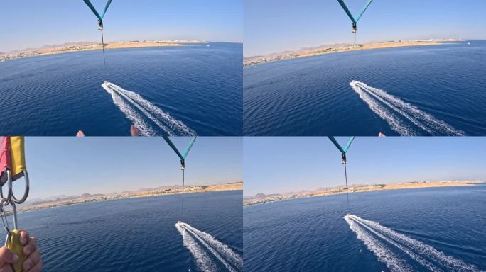 滑翔伞水上娱乐-在埃及红海度假胜地的海边，乘坐降落伞在船上飞行。