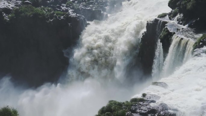 巨大的飞溅的水，巨大的瀑布撞击到下面的大跳水池，坚硬的侵蚀岩石景观从侵略性的瀑布水流在伊瓜苏瀑布，阿