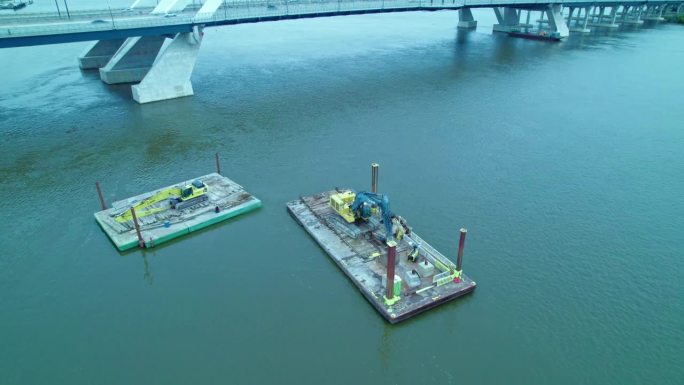美国爱荷华州达文波特百年大桥上的密西西比河浮船坞浮桥上的建筑机械。无人机的观点