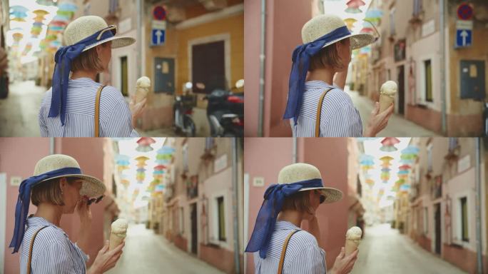 一名女游客走在克罗地亚村庄的街道上，一边吃着新鲜的甜筒冰淇淋