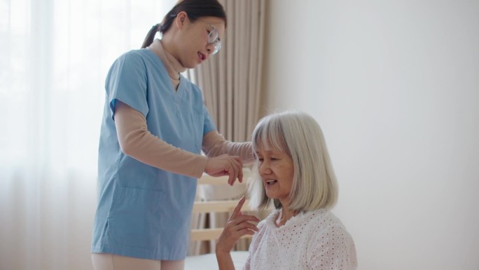 护士在养老院帮助老年妇女装卧室