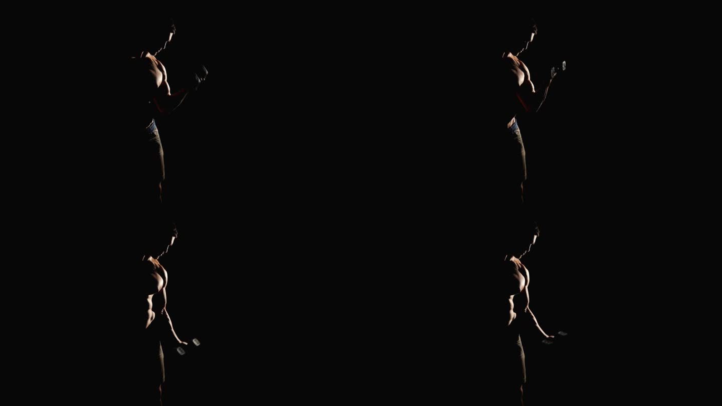 剪影的运动男子健美运动员锻炼哑铃在黑色的背景