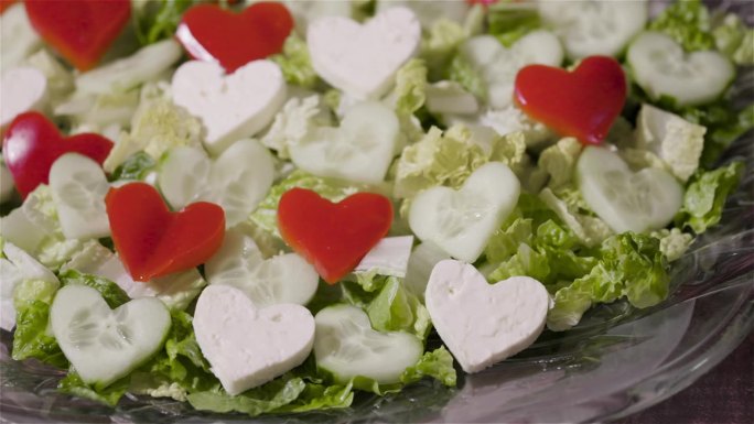 新鲜的沙拉，盘子里有红、绿、白的心形图案。