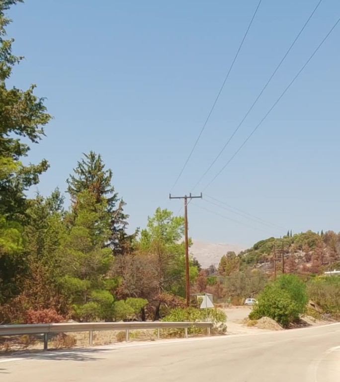 垂直视频-沿着蜿蜒的道路在丘陵乡村，罗德岛，希腊前进