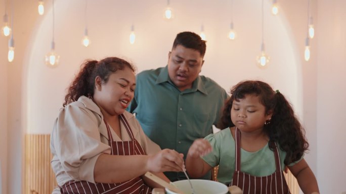 快乐的亚洲家庭在现代厨房一起烹饪健康沙拉——家庭幸福与烹饪的结合。