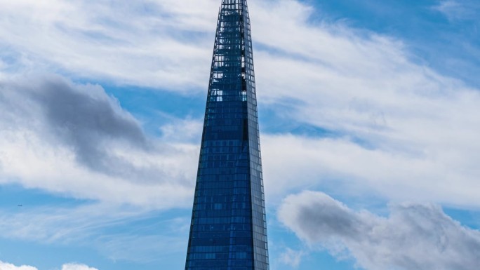 低角度拍摄的高耸的公司大楼，在高耸的建筑物和玻璃建筑中心，云层反射的摩天大楼，英国，英国，英国