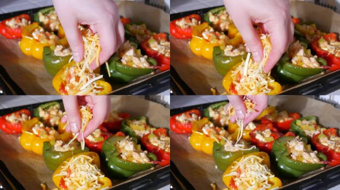 女人的手撒上切碎的奶酪红辣椒分成两半，黄的，红的，绿的，好吃的，里面塞着烤好的肉，上面撒上奶酪