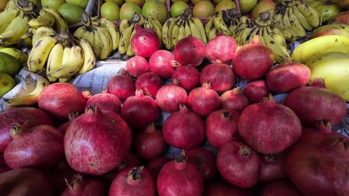 当地人在巴基斯坦旁遮普的水果摊上卖新鲜水果，石榴，葡萄
