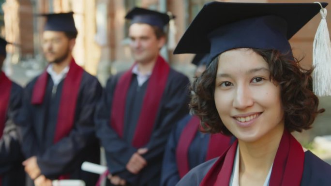 站在学生旁边听告别演讲的大学生看着镜头