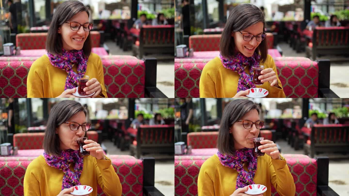 伊斯坦布尔，一名年轻女子在路边咖啡馆喝土耳其茶