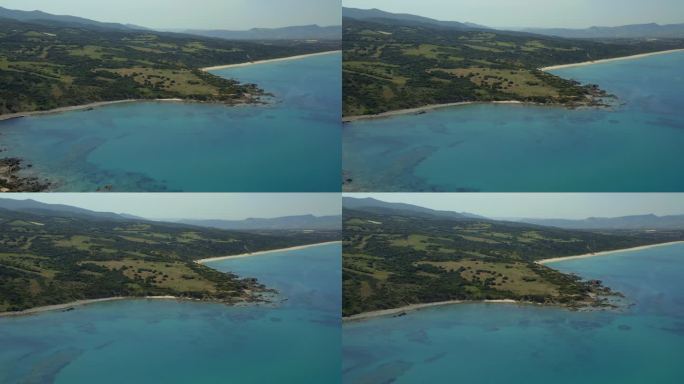 无人机的原始撒丁岛海岸线与充满活力的蓝色海水，岩石海岸，和郁郁葱葱的绿色景观，展示了意大利的自然之美
