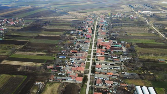 航拍画面捕捉到一条主要道路蜿蜒穿过一个有农舍的村庄