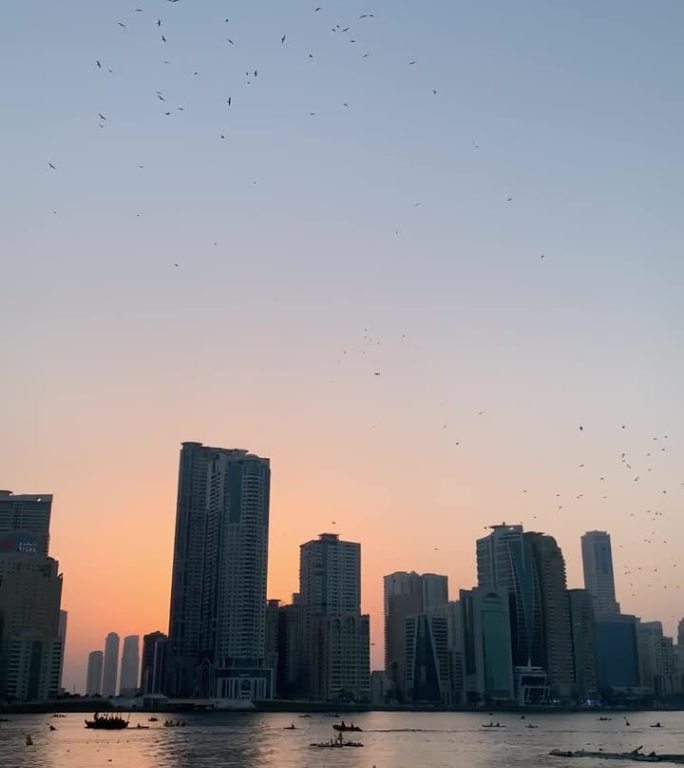 日落时分，阿拉伯联合酋长国沙迦市中心有摩天大楼和河流