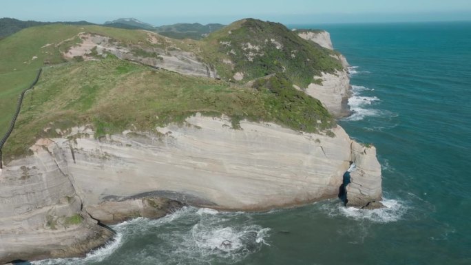 令人惊叹的鸟瞰图从遥远的永别角岬角的荒野海岸景观上升起，在新西兰奥特罗阿，波涛汹涌的海浪冲击着悬崖