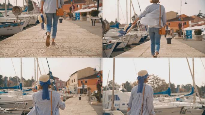 女游客带着吊带包，戴着太阳帽，走在克罗地亚村庄的港口码头上