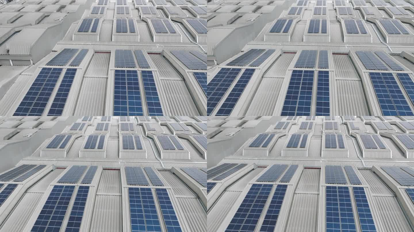 电力制造业厂房屋顶上许多太阳能电池屋顶农场的高角度面视图或无人机视图。