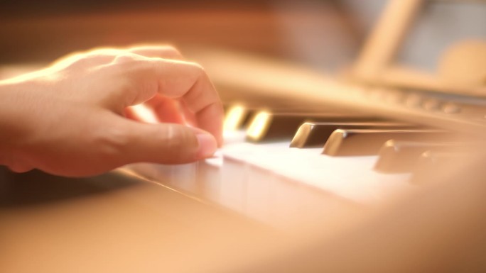 年轻女子弹钢琴的特写镜头。快乐的亚洲女性学习和练习钢琴。有选择性的重点。