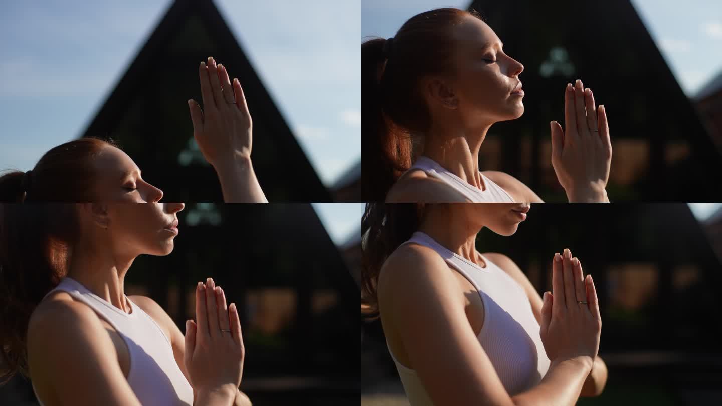 夏季阳光明媚的一天，在乡村别墅外，平静的瑜伽女性在户外把手放在合十手印姿势的特写跟踪拍摄。