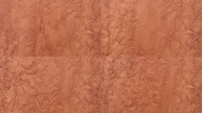 背景是沙漠中沿着沙丘流下的红色沙子。沙子倾泻而下